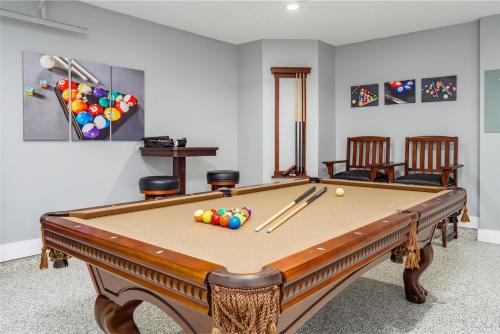a pool table in a room with balls and cuesticks at Phenomenal 7BR 4 Master Suites Southeast Pool Hot Tub Gas BBQ 2 Miles to Disney in Orlando