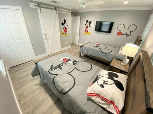 a bedroom with two beds with mickey mouse decals on the walls at Phenomenal 7BR 4 Master Suites Southeast Pool Hot Tub Gas BBQ 2 Miles to Disney in Orlando