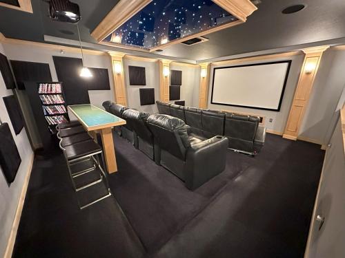 a movie room with leather chairs and a screen at Luxurious Getaway Pool Hot Tub Theater Gym Outdoor Kitchen BBQ 2 Miles to Disney in Orlando