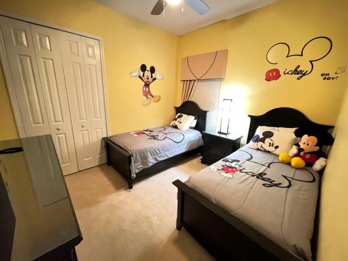 a bedroom with two beds and mickey mouse decals at Luxurious Getaway Pool Hot Tub Theater Gym Outdoor Kitchen BBQ 2 Miles to Disney in Orlando
