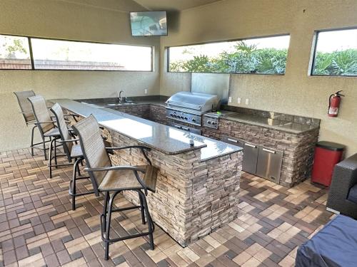 a kitchen with a counter and chairs in a room at Luxurious Getaway Pool Hot Tub Theater Gym Outdoor Kitchen BBQ 2 Miles to Disney in Orlando