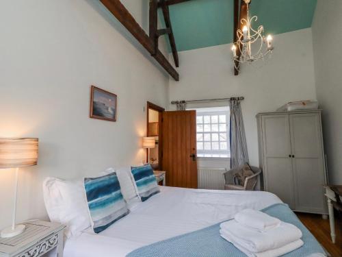 a bedroom with a bed with white sheets and blue pillows at No9 Budle Sands in Bamburgh