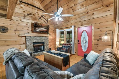 a living room with a couch and a fireplace at Smokies Log Cabin Hot Tub, Fire Pit & Arcade in Townsend