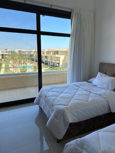 a bedroom with a bed and a large window at Penthouse El Gouna, Hurghada in El Gouna