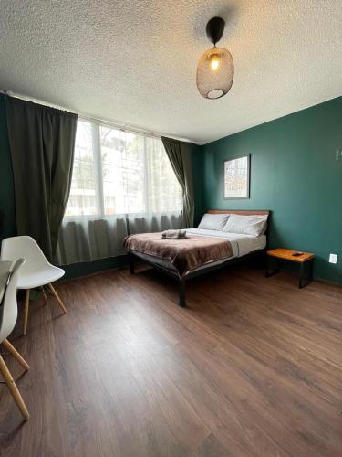 a bedroom with a bed in a green wall at Bright Studio Apartment Casa Icacos Apt 2 in Mexico City
