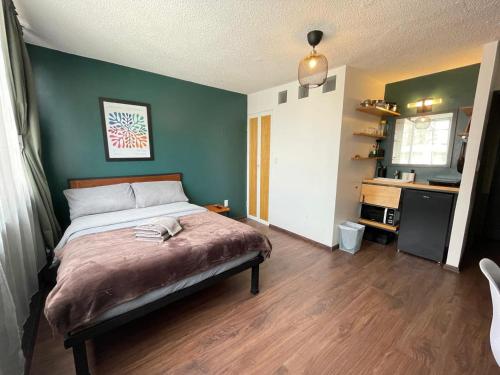 a bedroom with a bed and a green wall at Bright Studio Apartment Casa Icacos Apt 2 in Mexico City