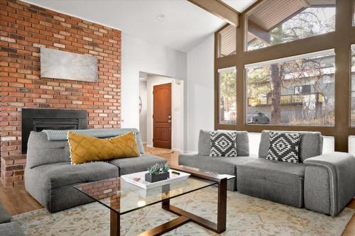 a living room with two couches and a brick wall at High Pines Lodge in Flagstaff