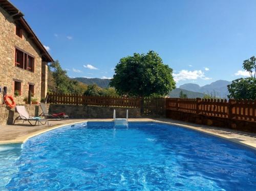 a large swimming pool in front of a house at Apart con piscina Lebanes Picos de Europa in Torices