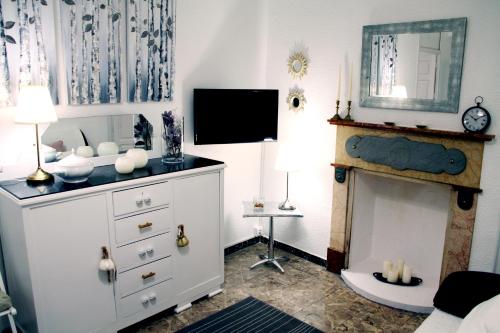 Casa Jazmín في بليانة: غرفة معيشة مع موقد وخزانة بيضاء
