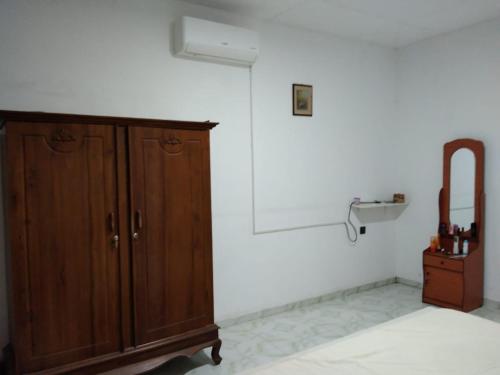 a room with a wooden cabinet and a mirror at Lankadays in Negombo