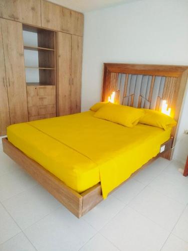 a large yellow bed in a room with two candles at Apartamento karey 506 in Santa Marta