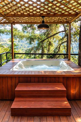 a hot tub on a deck with a pergola at OMGHAT Glamping in El Peñol