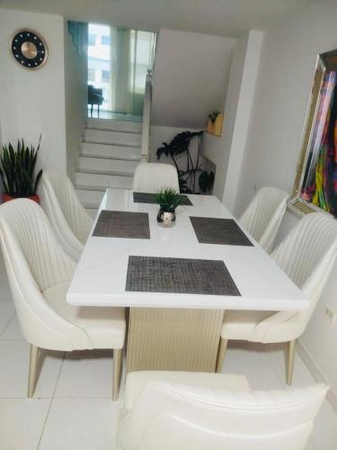 a white table and chairs in a room with stairs at Apartamento karey 506 in Santa Marta