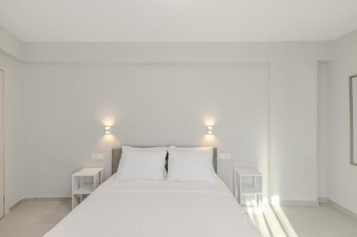 a white bed with two pillows in a room at Villa Nazar in Xiropigado