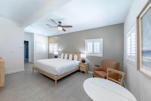 a bedroom with a bed and a chair and a ceiling fan at The Palmetto Inn in Boca Grande