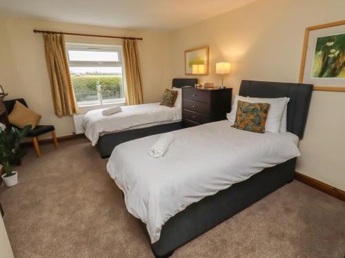 a bedroom with two beds and a window at The Retreat in Alnwick