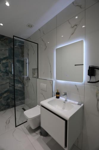 a white bathroom with a sink and a toilet at STAR Hotel in Bathore