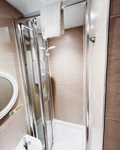 a shower with a glass door in a bathroom at Old Town Castle Apartment in Edinburgh