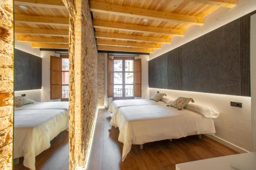 two beds in a room with wooden ceilings at Patio Nazarí Suites in Granada