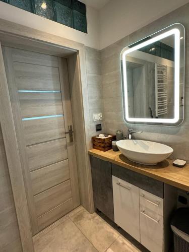 a bathroom with a sink and a mirror at Domek z jacuzzi Studnica 39 in Studnica