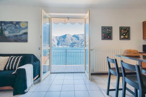 a room with a bed and a balcony with a view of the ocean at Alba on Lake Como by Rent All Como in Sala Comacina