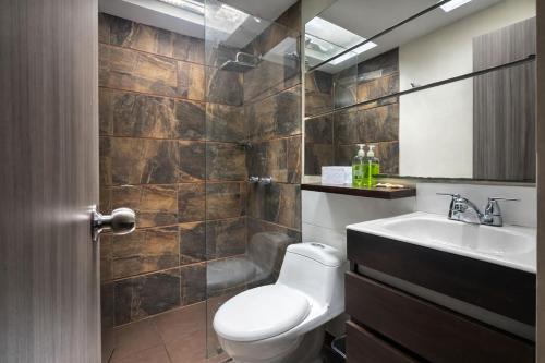 a bathroom with a toilet and a sink at Hotel Gallery Boutique in Pereira