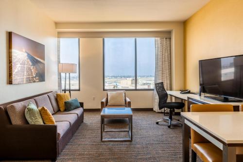 a living room with a couch and a flat screen tv at Residence Inn by Marriott Los Angeles LAX/Century Boulevard in Los Angeles