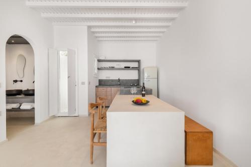 a kitchen with white walls and a table and chairs at Sunset Cove in Agios Ioannis Mykonos