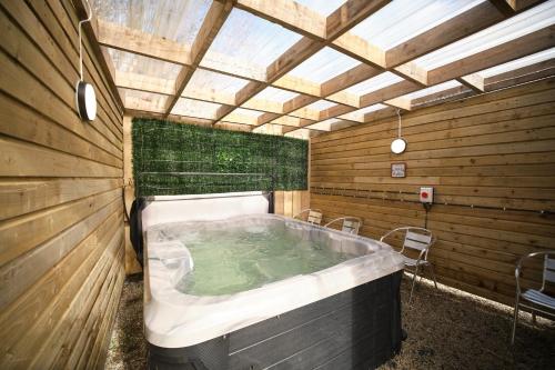 a jacuzzi tub in a wooden room with a ceiling at 1 Bedroom Lodge By Travel Lets Self Catering Accommodation Rathmullen With Hot Tub in Ramelton