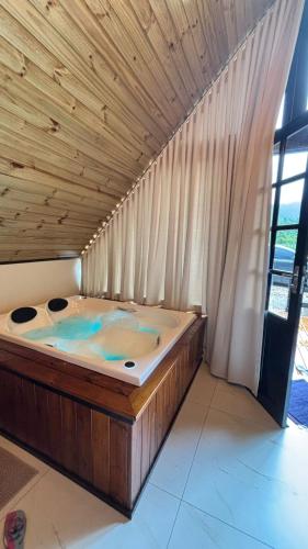 a large wooden bed in a room with a window at Sombra do baú -Luar in Timbe do Sul