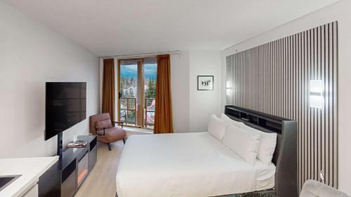 a hotel room with a white bed and a couch at Cascade Lodge in Whistler