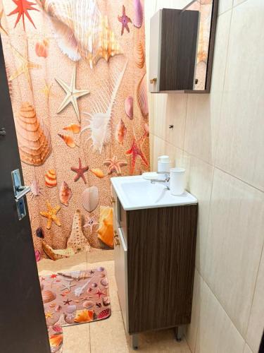 a bathroom with a sink and a wall with shells at GuestHouse Encanto del Centro 2 in Encarnación