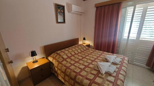 a small bedroom with a bed and a window at Manors Seaside 2BR House 100m from the Beach & Free Parking in Meneou