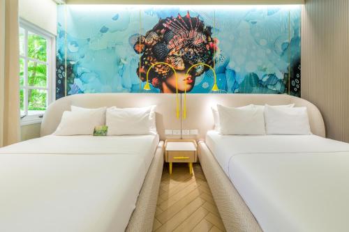 two beds in a room with a painting on the wall at Trupial Hotel & Casino in Willemstad