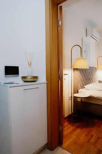 a room with a bed and a room with a refrigerator at Bellavista Garden in Baošići