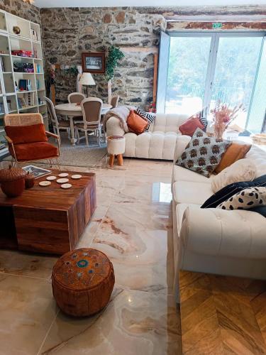 a living room with white furniture and a stone wall at Casa do Romezal in Peso da Régua