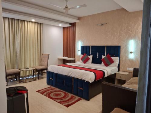 a hotel room with a large bed and a couch at Hotel Royal Stay in Gurgaon