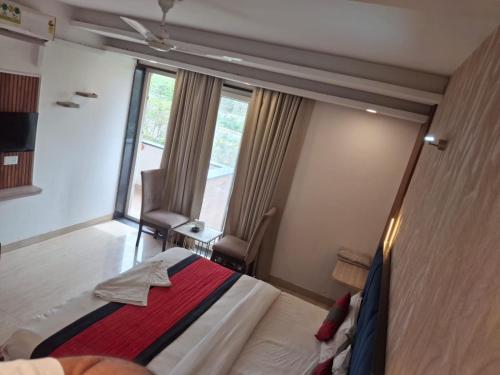 a hotel room with a bed and a large window at Hotel Royal Stay in Gurgaon