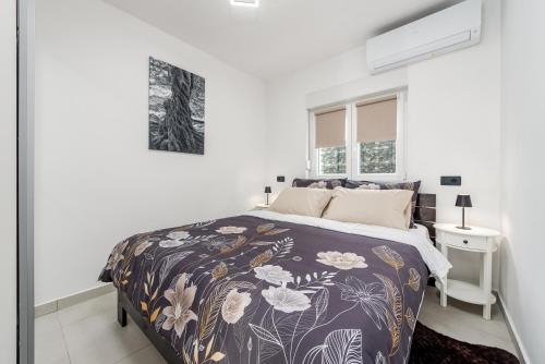 a white bedroom with a bed and a window at Apartmani Opg Dragoslavić in Stari Vas