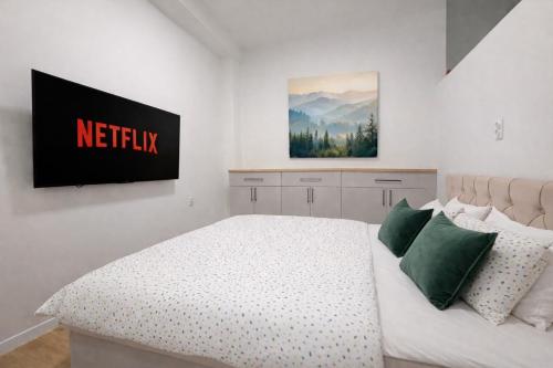 a bedroom with a bed with a netflix sign on the wall at Station APA s parkovaním in Michalovce
