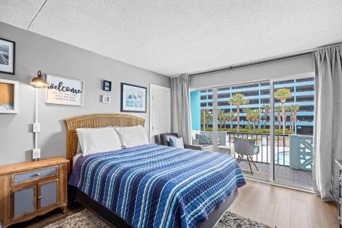 a bedroom with a bed and a large window at Pool Front & Across from Beach in Myrtle Beach