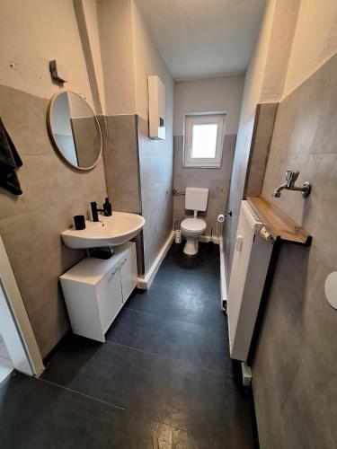 a bathroom with a sink and a toilet and a mirror at Gutliegende Wohnung in Maybach