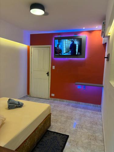 a room with two beds and a tv on a wall at HOTEL SMART LOVE in Carapicuíba