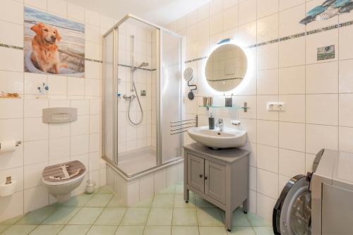 a bathroom with a shower and a dog on the wall at Haus Strandoase 04 in Bansin