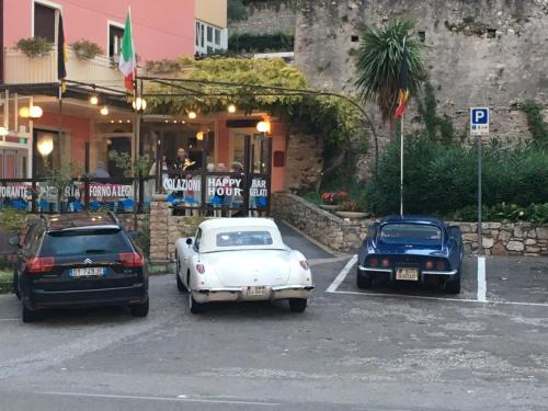three cars parked in a parking lot in front of a restaurant at Hotel Vela Azzurra in Malcesine
