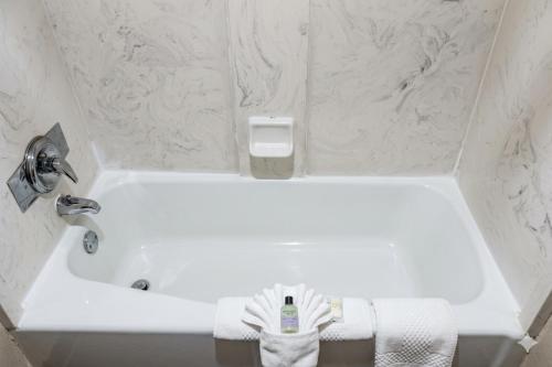 a white bath tub in a bathroom with white towels at Quality Inn & Suites Moline Airport in Moline