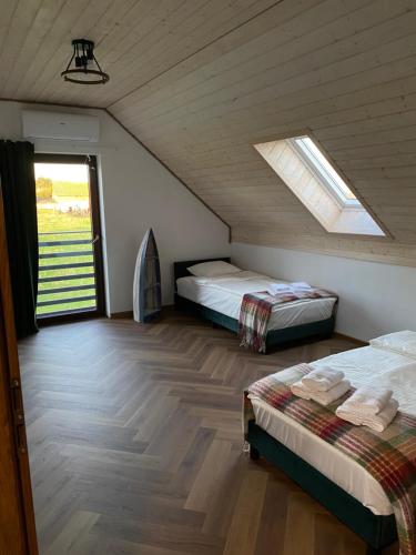 a attic bedroom with two beds and a skylight at Białe Żagle Mazury in Węgorzewo