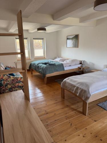 a bedroom with three beds and a wooden floor at Ferienhaus Big Family in Ellrich