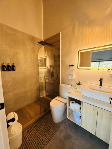 a bathroom with a toilet and a sink and a shower at Stillness Suite - Tamarindo - Pinilla - Avellanas - Pool - BBQ in San José Pinilla