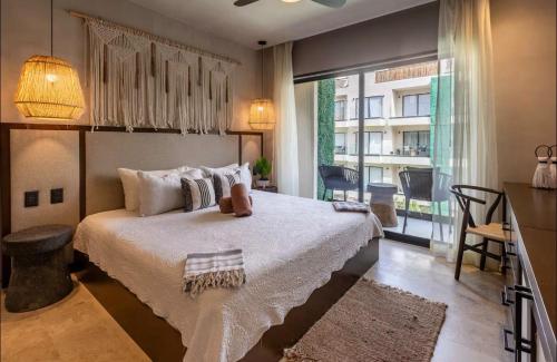 a bedroom with a large bed and a large window at Bakal Luxury condos in Tulum